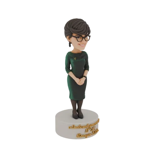 3D модель кивающей фигурки женщины в зеленом платье, в очках, стоящей на подставке с тамильской надписью.