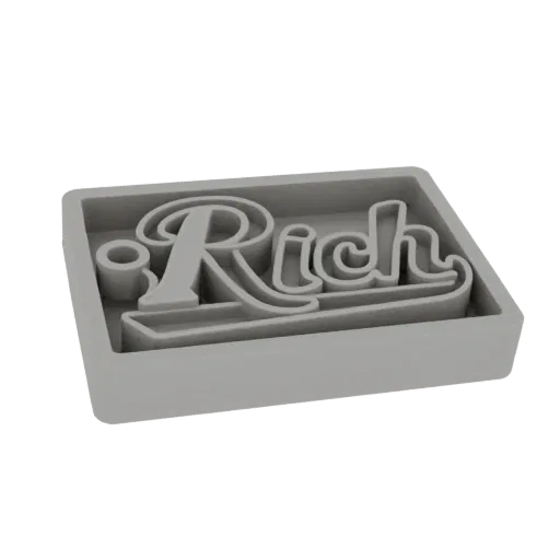 3D-рендер серой вырубки для печенья со словом 'Rich' стилизованным шрифтом.