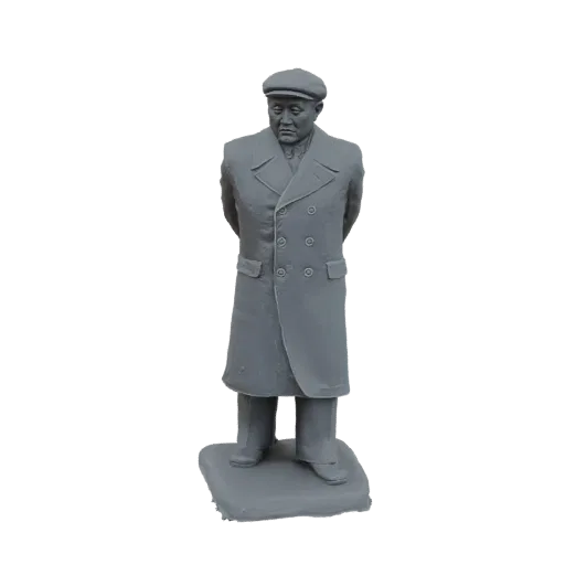 3D модель серой статуи мужчины в длинном пальто и кепке, стоящего со сцепленными за спиной руками на подставке.