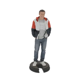 3D модель мужчины в красно-бело-синей толстовке и синих джинсах, стоящего с руками в карманах на круглой подставке.
