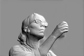 3D модель барельефа женщины в очках, держащей предмет, сфокусированный взгляд, детализированное лицо и руки