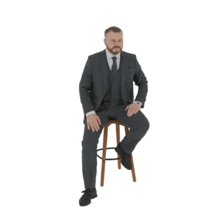 3D модель мужчины в темном костюме, сидящего на деревянном стуле, смотрящего немного в сторону.