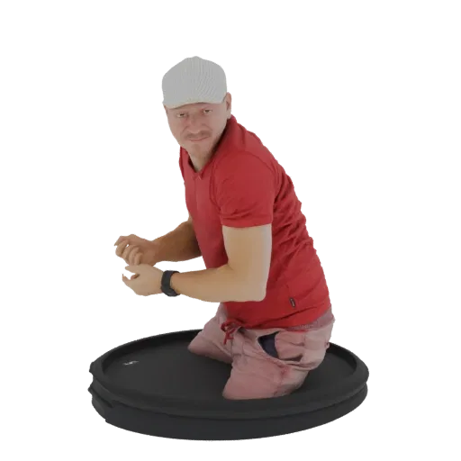 3D модель мужчины в красной поло и розоватых шортах, стоящего на коленях на черной круглой платформе и смотрящего на зрителя.