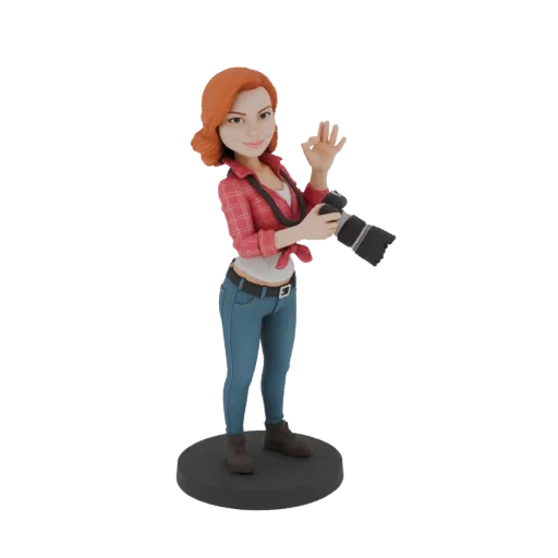 3D модель женщины-фотографа с рыжими волосами, держащей камеру и показывающей знак 'окей', на черном основании.