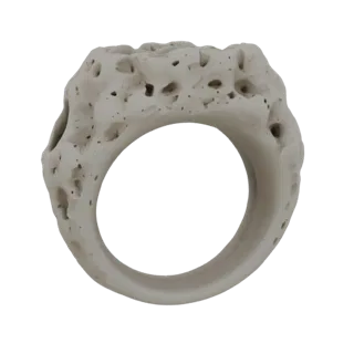 3D-модель кольца с грубой, пористой, органической текстурой, напоминающей выветренную кость или коралл.