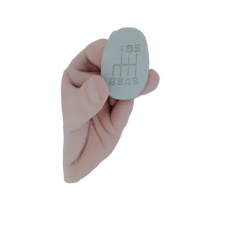 3D модель светло-серой овальной ручки КПП 5-ступенчатой с тиснением H-образного рисунка переключения передач на поверхности,