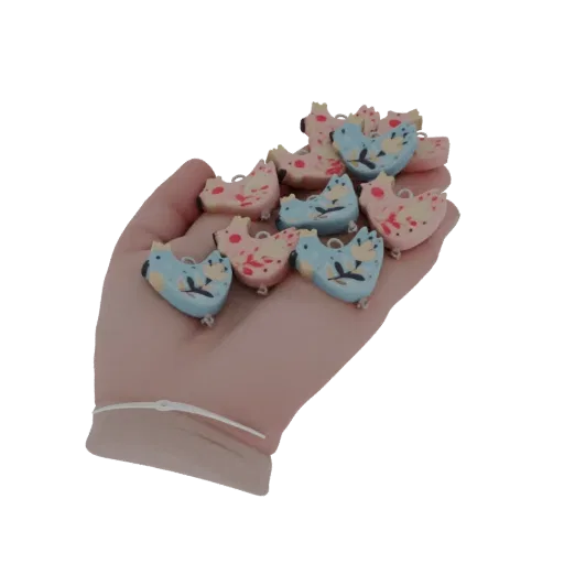 Рука держит коллекцию маленьких, красочных 3D подвесок-курочек с замысловатыми узорами.