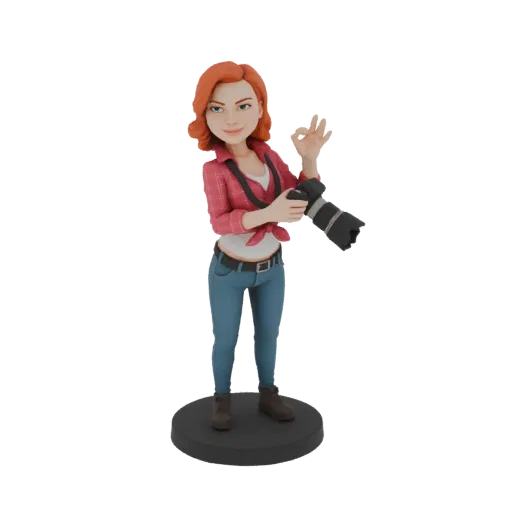 3D модель фотографа с рыжими волосами, держащая камеру и показывающая жест 'окей', на черной подставке.